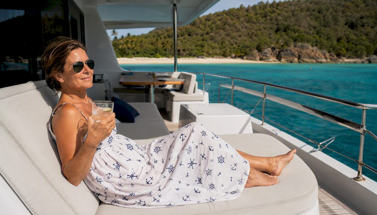Woman steering power catamaran in Caribbean clear waters