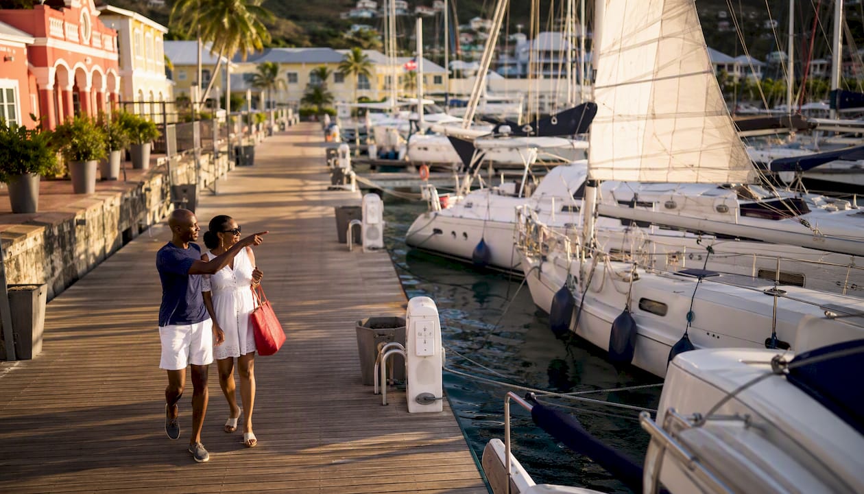 Couple walking along Tortola marina promenade