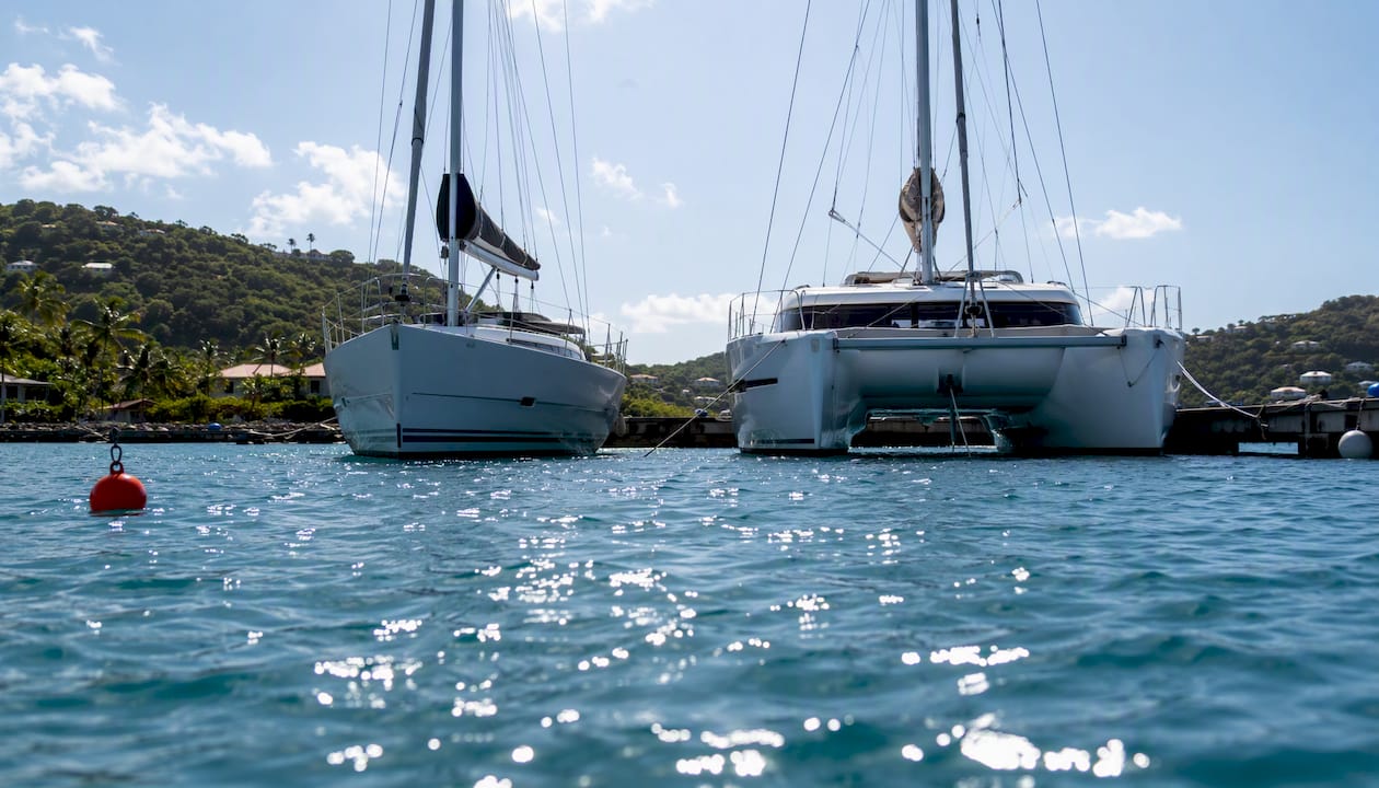 Monohull and catamaran side-by-side at anchor