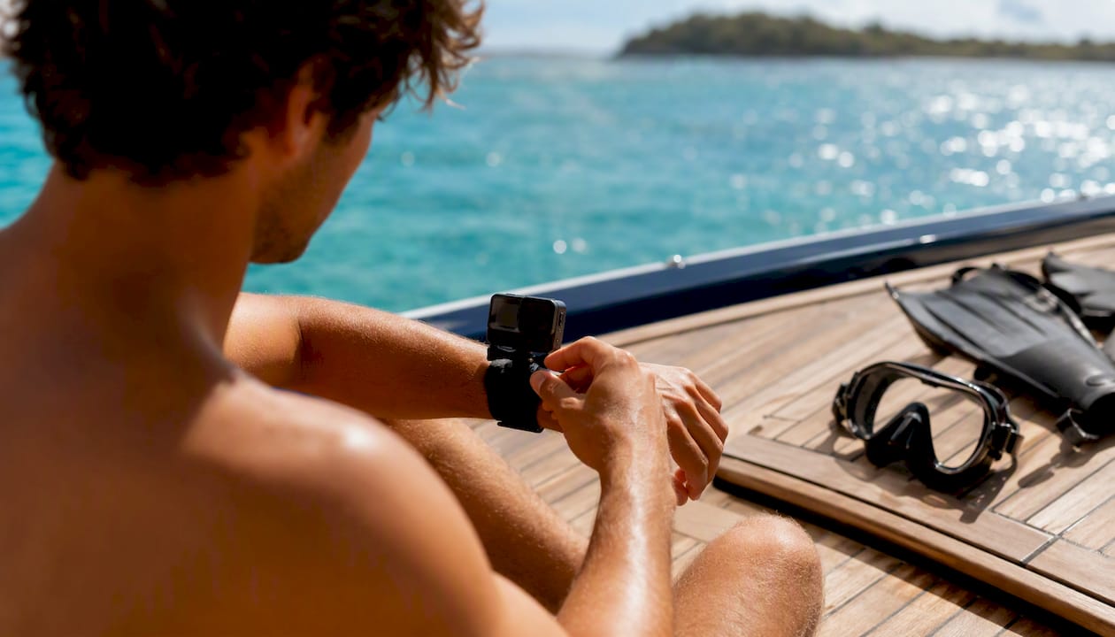 Hands preparing underwater camera and snorkel gear