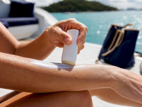 Person applying mineral sunscreen on yacht deck