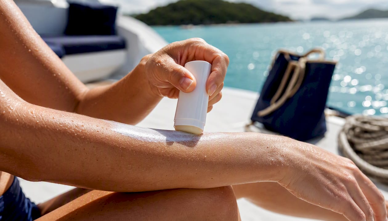 Person applying mineral sunscreen on yacht deck