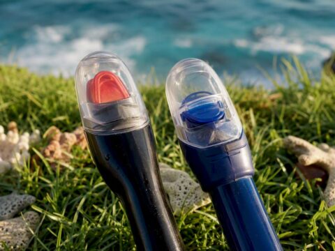 Close-up of snorkel valve tops on beach sand