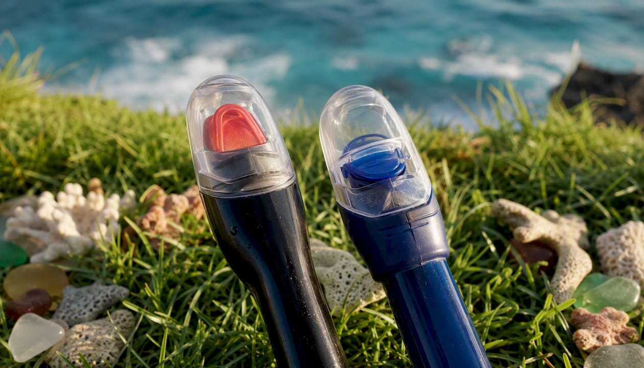 Close-up of snorkel valve tops on beach sand