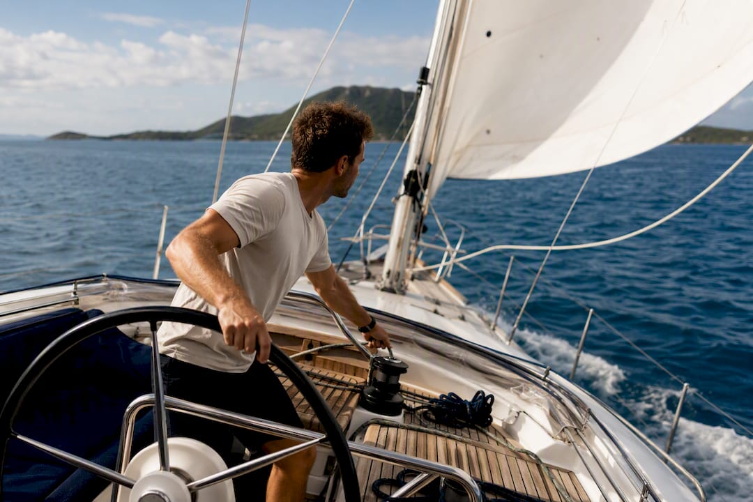 Sailor steering and adjusting lines during docking