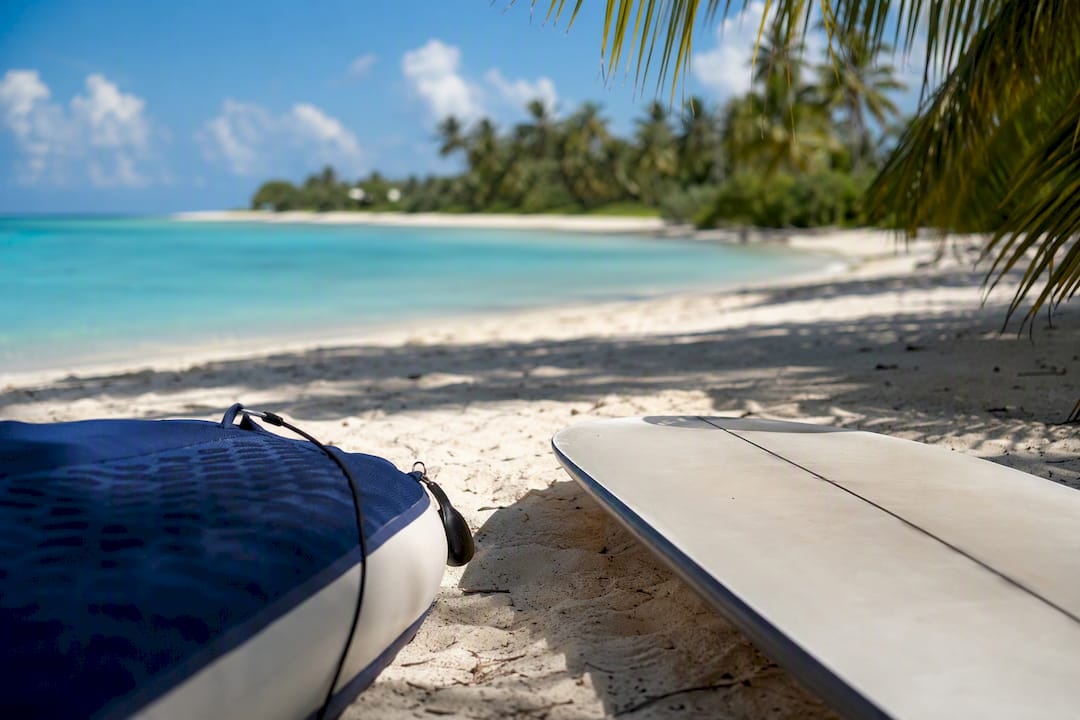 Partial inflatable and hard paddle boards on beach sand