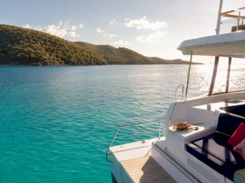 Luxury power catamaran anchored in turquoise tropical bay