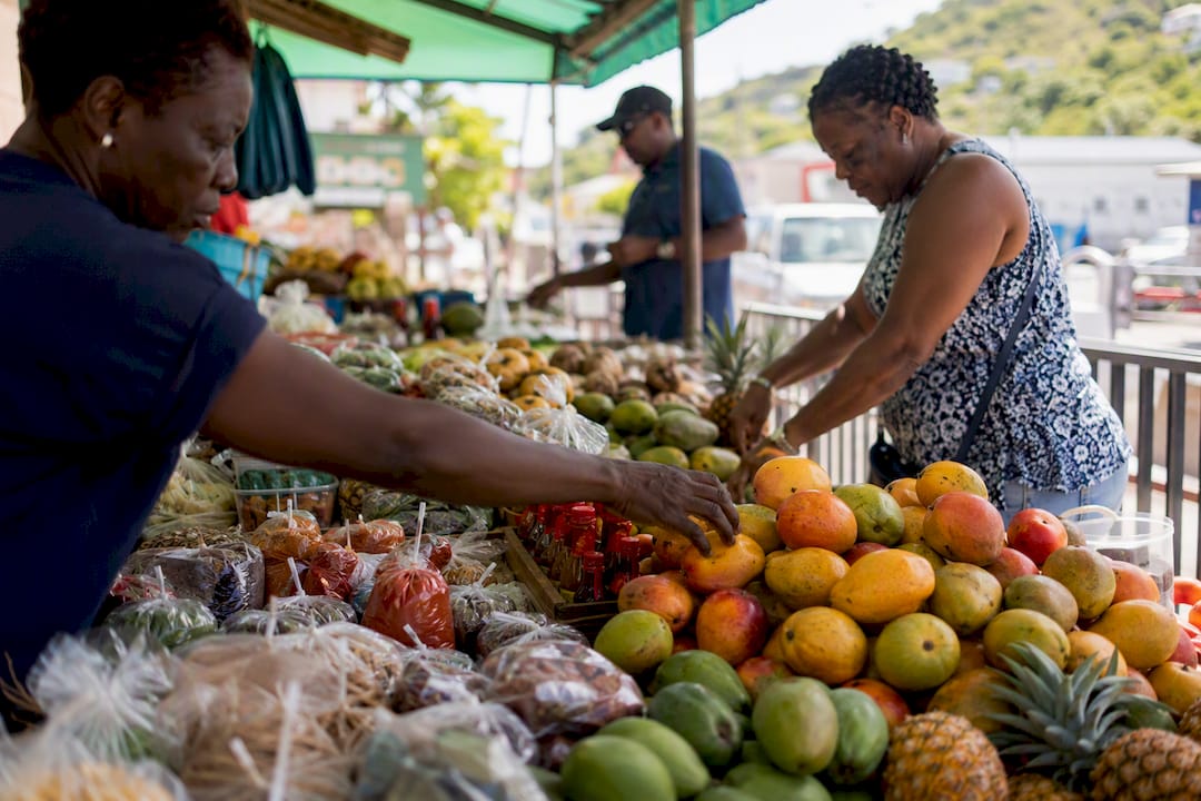 Hands arranging tropical fruits at Tortola market