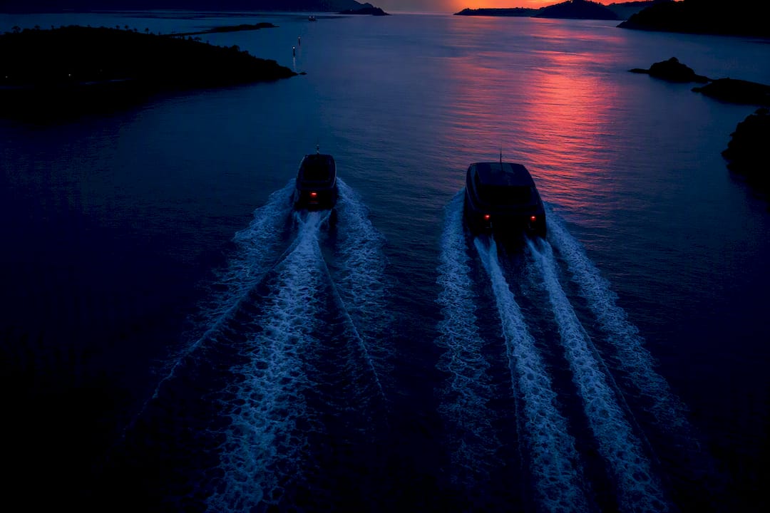 Anonymous yacht hulls crossing Caribbean water