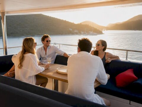Guests gathering on a flybridge at golden hour