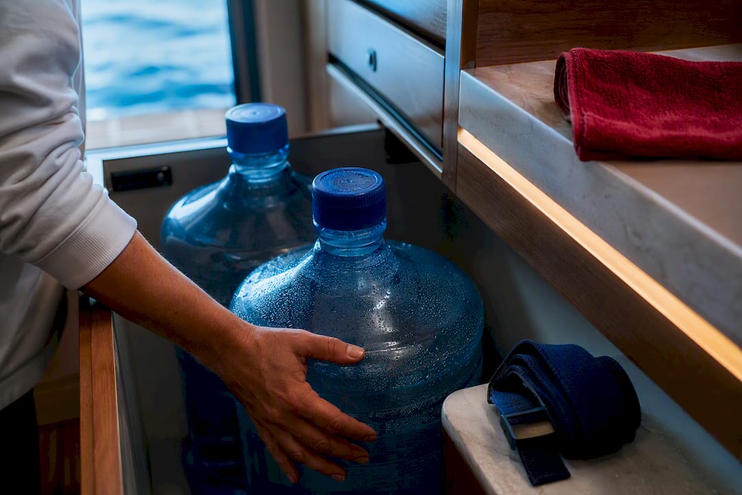 Large water jugs secured in yacht storage