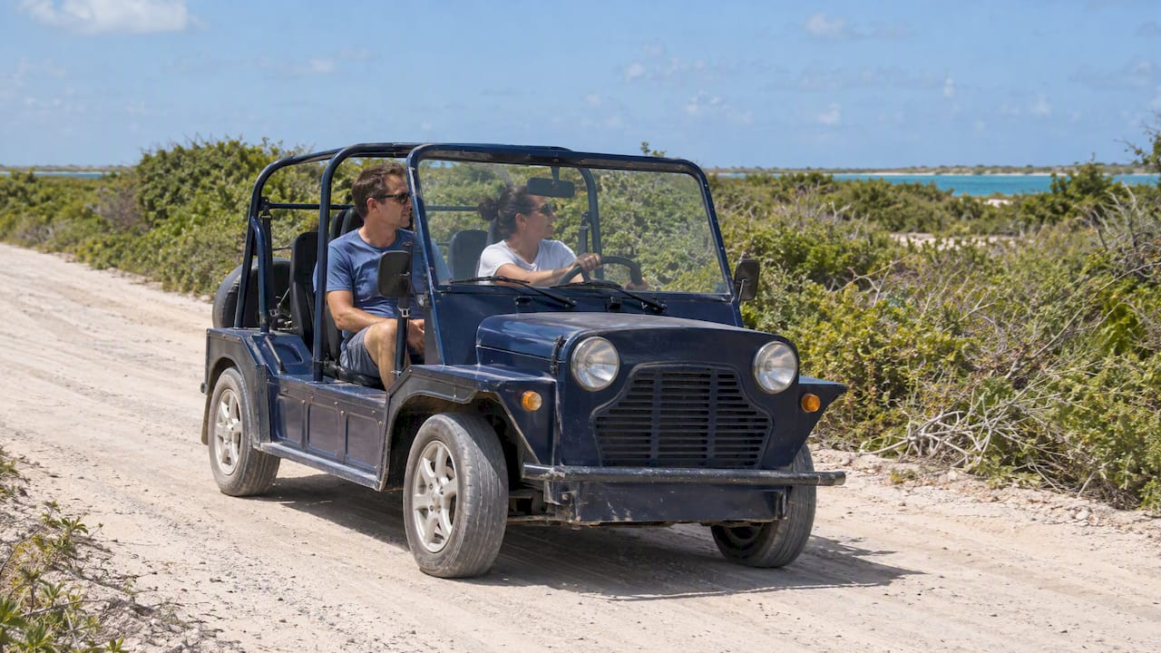 Visitors driving an open-air moke across Anegada