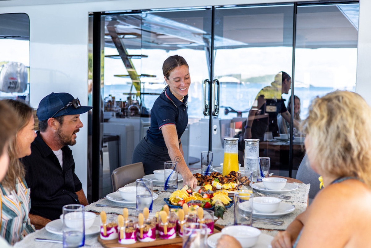 stewardess serving guests on a luxury Catamaran charter